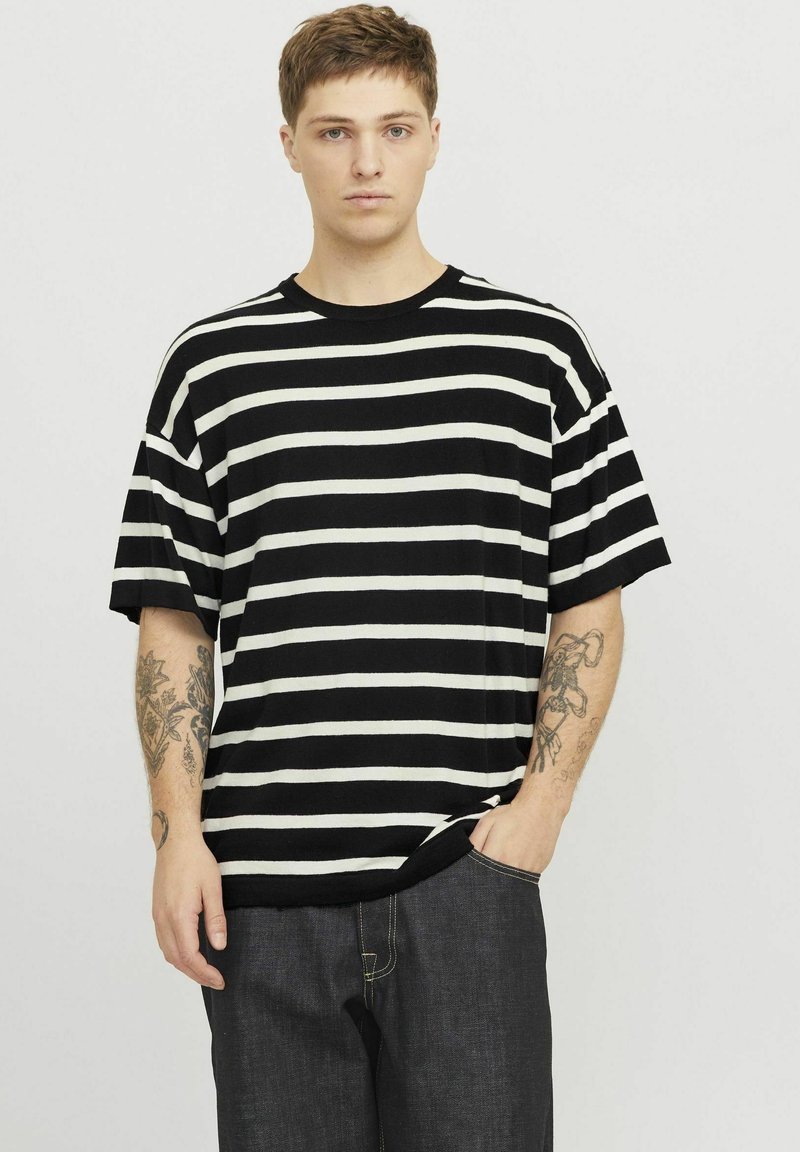 Sort og hvid stribet kortærmet t-shirt med rund hals, lavet af blødt stof, løs pasform, der har tydelige vandrette striber.