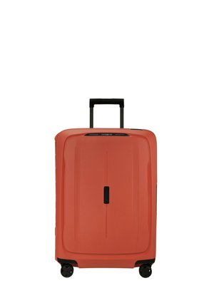 Large coral hard-shell suitcase with black retractable handle and four spinner wheels, standing upright on a white background.