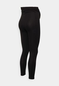 Leggings pretas com uma cintura alta, feitas de um material liso e flexível. Apresenta um design ajustado com pernas afuniladas e sem padrões visíveis.