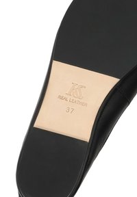 Semelle d'une chaussure en cuir noir indiquant la taille 37 et l'étiquette "Cuir véritable" avec les initiales de la marque embossées "KS".