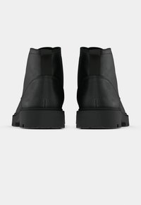 Black ankle boots with a smooth finish, elastic side panels, and a textured rubber sole. Classic design with streamlined shape.