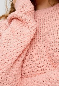 Pull en tricot rose avec un motif texturé à mailles lâches, des poignets côtelés et une coupe décontractée. Matière douce et confortable.