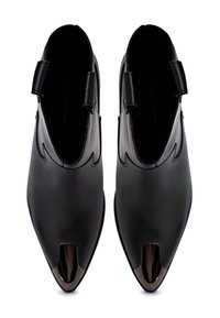 Bottines en cuir noir avec un bout pointu et un design découpé. Présentent un bout en cuir noir brillant et une texture lisse.