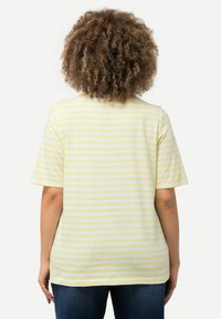 Camiseta a rayas de algodón amarilla y blanca, con mangas cortas, cuello redondo y un corte relajado. Vista trasera mostrando rayas horizontales.