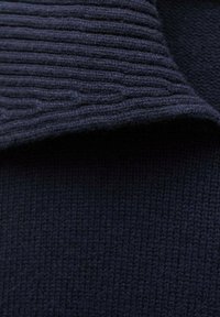 Dark navy ribbed knit fabric folded over smooth knit fabric, showing texture contrast and deep color.