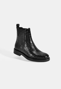 Bottes ajustées en cuir noir avec un motif crocodile brillant, panneaux latéraux élastiques, bout arrondi et un petit talon carré.
