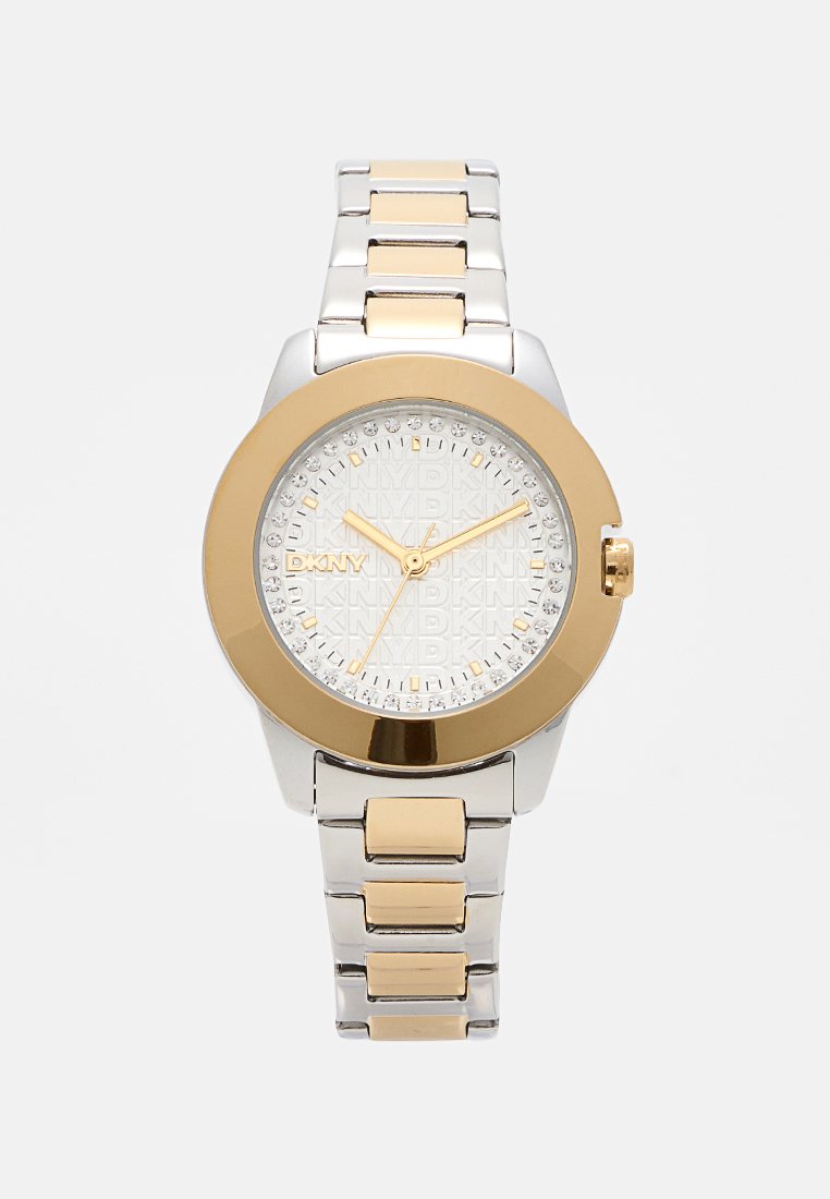 Montre-bracelet DKNY pour femmes en argent et or avec un cadran rond, lunette dorée, marqueurs d'heure en cristal et bracelet en métal bicolore.