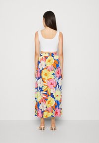 Kukkakuvioinen maksihame sinisellä taustalla, jossa on kirkkaita trooppisia kuvioita vaaleanpunaisena, keltaisena ja oranssina. Pehmeää kangasta ja joustava vyötärö.