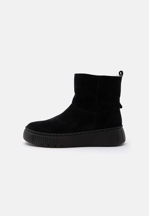 Black mid-calf suede boot with thick ribbed platform sole and pull tab at the back, shown in side view on a white background.