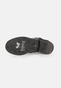 Suela negra de un zapato, texturizada con un agarre con patrón. Presenta un pequeño tacón y una marca en la planta, con marcas de uso visibles.