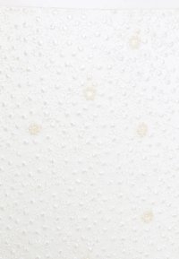 Tissu blanc à texture, orné de petits motifs floraux brodés et de perles éparpillées.