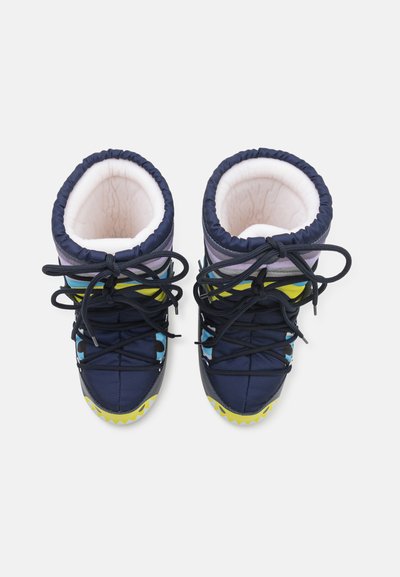 Keskmise kõrgusega talvesaapad, millel on tumesinine välimus, pehme valge vooder, mitmevärvilised aktsendid ja tekstureeritud kollane ja must tald.