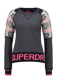 Pull en maille gris foncé, présentant des motifs de flocons de neige blancs et roses sur les manches. Ourlet côtelé noir avec "SUPERDRY" écrit en lettres roses en gras.
