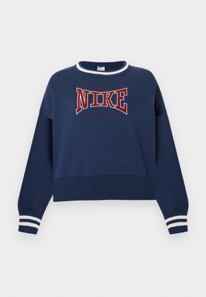 Laivastonsininen Nike-collegepaita, jossa punavalkoinen "NIKE ATHLETIC DEPT." -teksti, valkoiset raidalliset hihansuut ja valkoinen reunus kauluksessa yksivärisellä pohjalla.