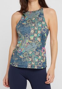 Hihaton paita monivärisellä kukka- ja geometrisella kuviolla sinisellä taustalla. Valmistettu kevyestä kankaasta ja istuvalla leikkauksella.