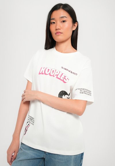 Biely bavlnený tričko s výrazným ružovým nápisom "KOOPLES" a grafickými potlačami, má krátke rukávy a voľný strih. Doplnky obsahujú textové detaily.