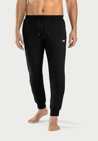 Schwarze sportliche Jogginghosen aus weichem Stoff, mit einem elastischen Bund und Kordelzug sowie gerippten Knöchelabschlüssen. Kleines, hellblaues Logo-Detail.