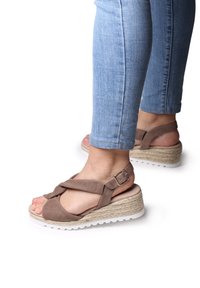 Sandali wedge in suede marrone con cinghie incrociate, fibbia sulla caviglia e piattaforma avvolta in juta. Suola in gomma bianca e testurizzata.