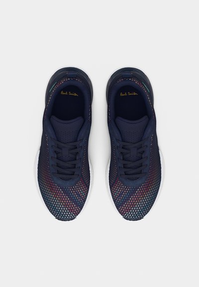 Ζευγάρι αθλητικά παπούτσια σκούρου ναυτικού χρώματος με πολύχρωμο διάτρητο επάνω μέρος και λευκές σόλες, σε θέα από ψηλά πάνω σε λευκό φόντο.