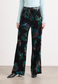 Pantaloni larghi din catifea neagră, având un model de pene multicolore în nuanțe de verde, albastru și violet. Înfășurați cu o închidere cu buton la talie.