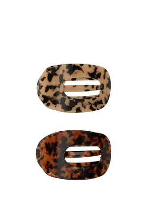 Due mollette ovale con motivo tartarugato, una beige chiaro con macchie scure, una marrone scuro con macchie nere, entrambe con aperture rettangolari centrali.