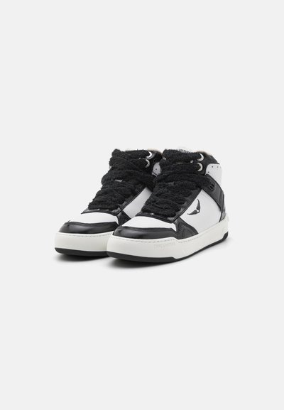 Black and white high-top sneakers with textured black laces, patent leather accents, and a white rubber sole. Notable logo on the side.