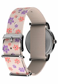 Montre Timex avec un bracelet beige à motif floral orné de fleurs violettes et roses. Le matériel en acier inoxydable rehausse le design.