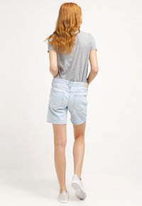 Ljusblå denimshorts med standard passform, med två bakfickor, en midjebandsetikett och en slät, något strukturerad yta.