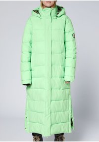 Langer, puffiger Mantel in Minzgrün mit hohem Kragen, seitlichen Schlitzen und tiermustergefütterter Kapuze. Verfügt über abgesteppten Einsätze und ein Logo-Patch.