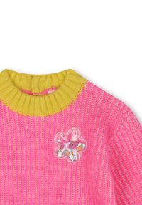 Pull en tricot rose vif avec un col en rib jaune et une patch transparente en forme de fleur avec des sequins sur le devant.