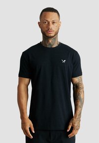 Czarny t-shirt z krótkim rękawem wykonany z bawełny, z małym białym logo skrzyżowanych mieczy na lewej piersi. Luźny krój z okrągłym dekoltem.