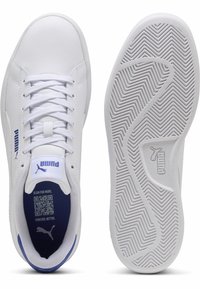 Scarpe sportive bianche con accenti blu, parte superiore strutturata, lacci piatti e suola in gomma testurizzata con un motivo a zigzag.