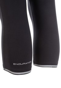 Zwarte knielange compressieleggings met een gladde textuur, voorzien van reflecterende zilveren accenten en de tekst "ENDURANCE" nabij de zoom.