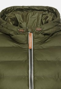 Olive green puffer jacket featuring a high collar, zip closure, and brown cord accents. Made of a smooth, lightweight material.