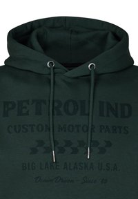 Sudadera verde oscuro con un bolsillo canguro en el frente, cordones y un gráfico impreso que dice "PETROL IND CUSTOM MOTOR PARTS" y otros elementos de texto.