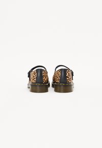 Schoenen met luipaardprint en zwarte leren accenten, met een stevige zool, een ronde achterkant en contrasterende gele stiksels langs de randen.