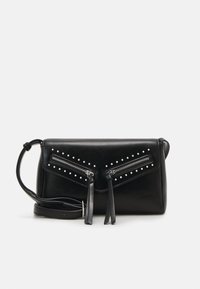 Czarna skórzana torba na ramię z dwoma ukośnymi kieszeniami na suwak i srebrnymi ćwiekami na jednolitym białym tle.