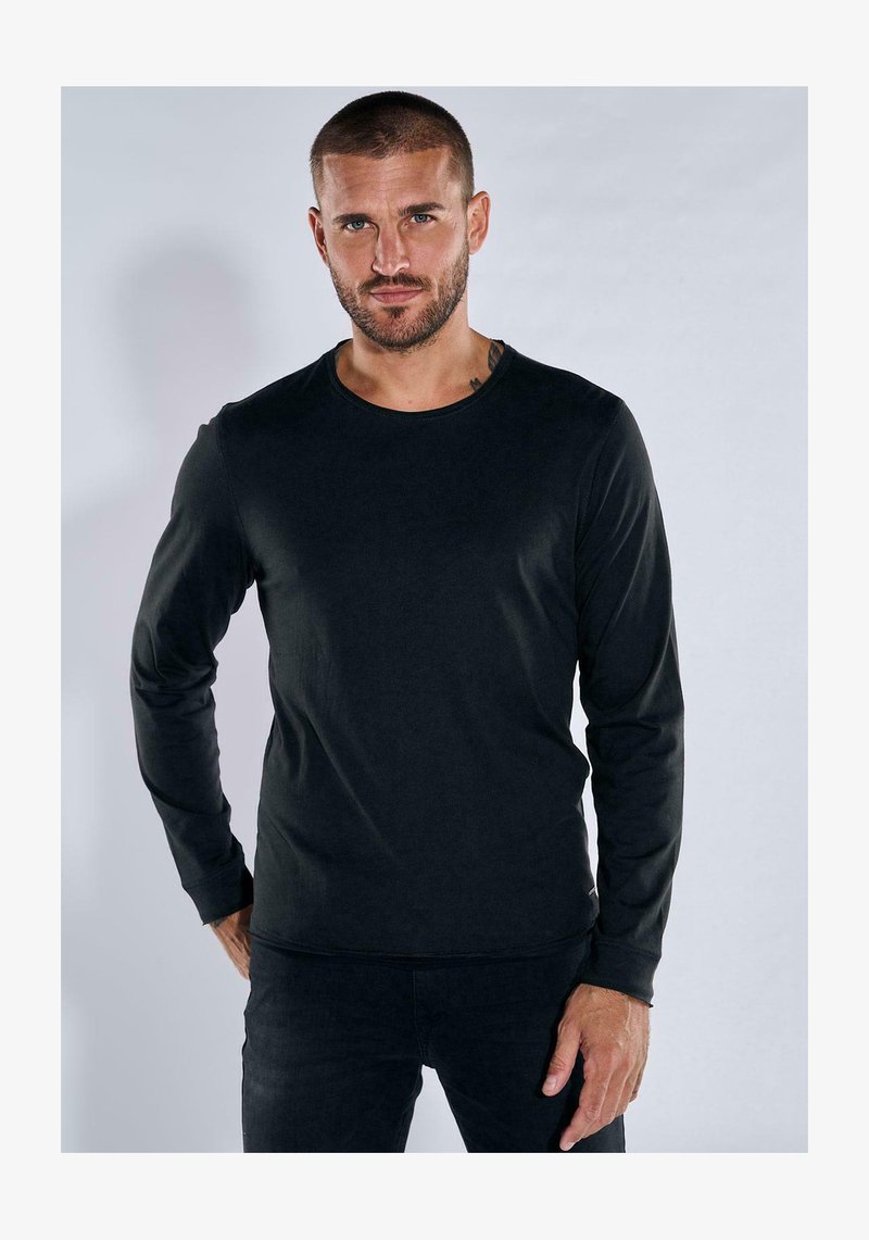 Black long-sleeve shirt made of smooth material, featuring a round neckline and fitted design. Subtle stitching detail along the hems.