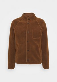 Giacca in pile marrone con collo alto, bottoni frontali, tasca al petto e tasche laterali, caratterizzata da una texture morbida e maniche raglan.