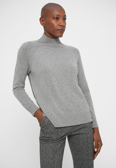 Pull en maille doux couleur gris clair avec col roulé, présentant des poignets et un ourlet côtelés, avec une coupe décontractée et des fentes latérales pour un confort supplémentaire.