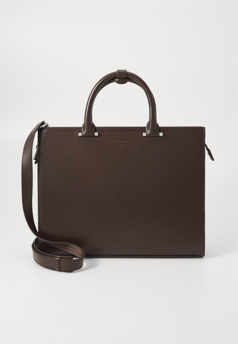 Καφέ δερμάτινη τσάντα με διπλές χερούλες, ρυθμιζόμενο λΟΥρί ώμου, ορθογώνιο σχήμα, ασημένια αξεσουάρ και λεία υφή.