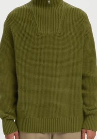 Oliwkowy sweter z dzianiny z wysokim kołnierzem, z teksturowanym wzorem oraz ściągaczami przy mankietach i dolnym brzegu, oferujący luźny krój.