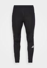 Black athletic leggings featuring a form-fitting design, made of stretchy material, with reflective side accents and a logo on the lower leg.
