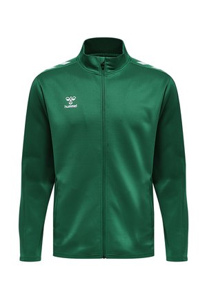 Grøn atletisk jakke lavet af glat stof. Har en høj krave, fuld lynlås foran og hvide accentstriber på skuldrene. Brandlogo vist.