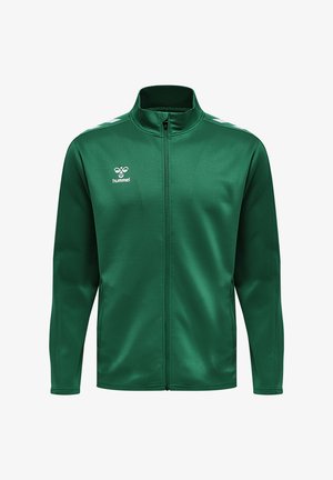 Grøn atletisk jakke lavet af glat stof. Har en høj krave, fuld lynlås foran og hvide accentstriber på skuldrene. Brandlogo vist.