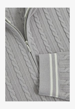 Helle graue Zip-Up-Weste mit einem Kabelstrickmuster, gerippten Bündchen mit weißen Streifen und einem glatten silbernen Reißverschluss.