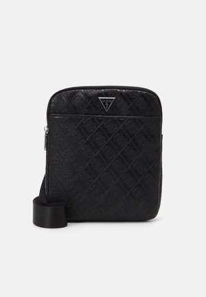 Sac bandoulière noir Guess avec motif diamant embossé, poche avant zippée, plaque logo triangulaire et bandoulière réglable.
