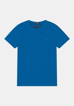 T-shirt blu a maniche corte con scollo rotondo e piccolo logo della bandiera Tommy Hilfiger sul lato sinistro del petto e etichetta in cotone biologico sul colletto.