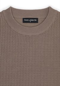 Brązowy sweter o teksturowanej powierzchni z prążkowanym dekoltem oraz metką z napisem "PAKO LORENTE M." Tkanina ma wzór przypominający gofry.