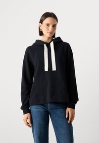 Jūrų kariuomenės mėlynas džemperis su gobtuvu, baltais raišteliais, ilgomis rankovėmis ir laisvu siluetu. Audinys turi lygų paviršių; paprastas dizainas be raštų.